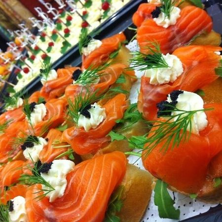 Belegte Schnittchen mit Räucherlachs, Frischkäse und Dill - appetitlich präsentiert auf Platten
