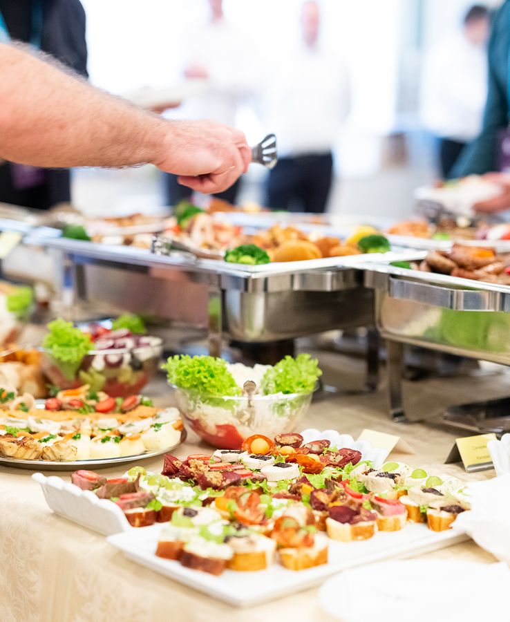 Buffet mit kalten und warmen Speisen, belegten Brötchen, Salaten und Platten, Gäste bedienen sich