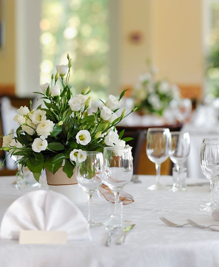 Festlich gedeckter Tisch mit Blumenarrangement, Gläsern und Servietten - bereit für ein Event